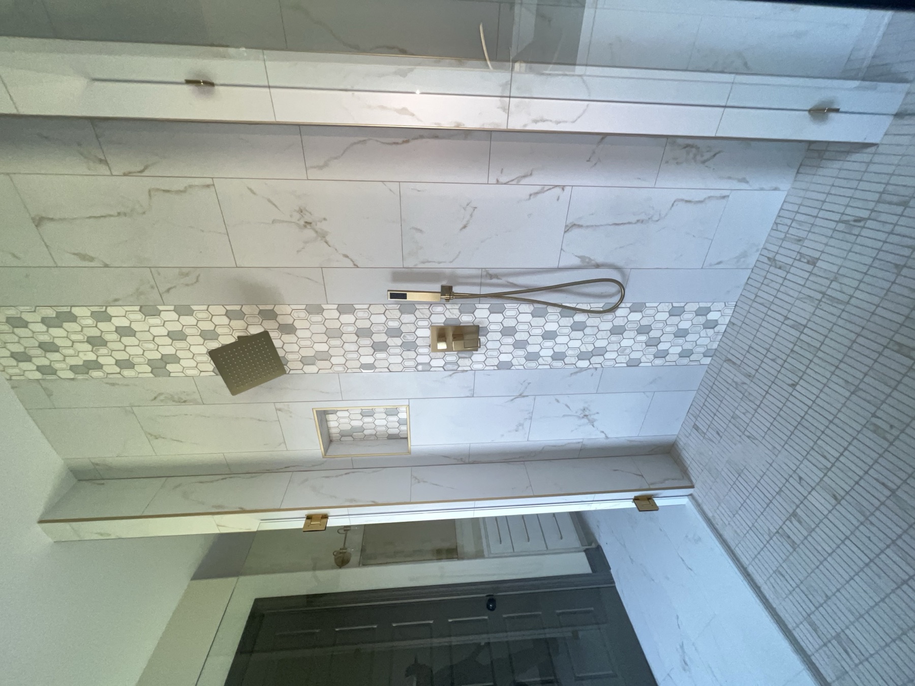 Marble tile shower with mosaic accent stripe